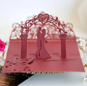 Macro view of laser-cut 3D wedding card with romantic couple silhouette and floral hollows