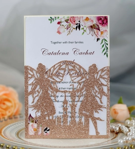 Detailed laser-cut castle and fairy pattern on rose gold glitter wedding invitation