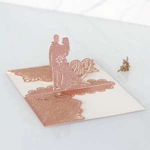 Dettaglio dell'invito di nozze intagliato al laser in carta glitterata oro rosa lucido