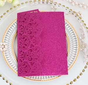Detail of laser-cut floral pattern on purple glitter wedding invitation sleeve