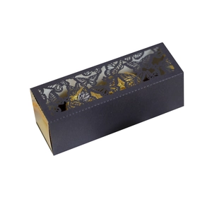 Macro detail of black gift box featuring laser-cut butterfly patterns and gold foil lining