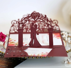 Macro detail of 3D pop-up wedding invitation featuring laser-cut burgundy heart arch