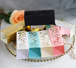 Elegant laser-cut hollow candy boxes with rose patterns in multiple colors for weddings