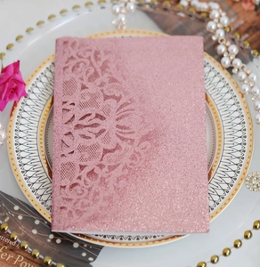Détail de dentelle florale découpée au laser sur invitation de mariage rose doré brillant