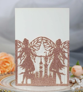 Close-up of rose gold glitter fairy castle laser cut invitation on a vintage ceramic plate