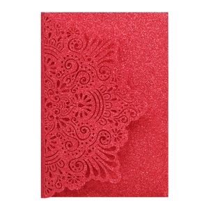 Dettaglio dell'invito di nozze rosso glitterato con intricato motivo mandala laser