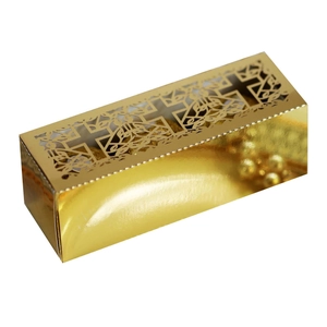 Macro shot of gold mirror finish gift box with laser-cut cross and floral hollow design