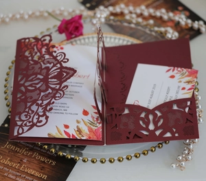 Detailed laser-cut lace wedding invitation in burgundy with floral insert cards