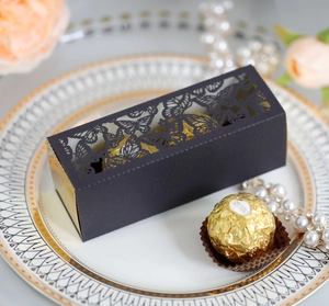Macro detail of laser-cut butterfly wedding favor box with elegant gold lining