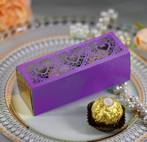 Close-up of purple laser-cut gift box with heart pattern and golden interior detail