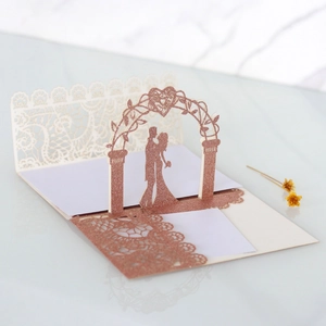 Macro detail of laser-cut 3D wedding invitation featuring rose gold glitter finish