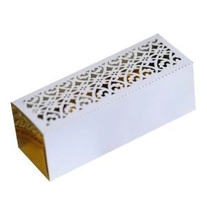 Detail of laser-cut floral pattern on white gift box with elegant gold inner layer