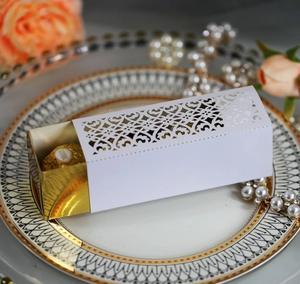 Detailed laser-cut hollow pattern on white paper wedding favor box with floral details