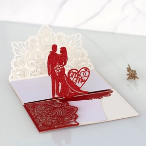 Dettaglio invito di nozze a taglio laser con silhouette rossa pop-up di sposo e sposa