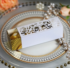 Detail of laser-cut vine hollow pattern on white and gold wedding candy favor box