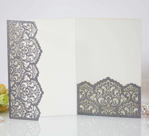 Detailed laser-cut silver glitter wedding invitation with elegant floral vine patterns