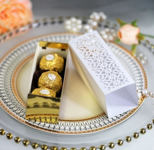 Detail of white laser-cut hollow candy box with gold inner tray for luxury chocolates