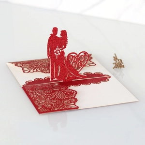 Dettaglio di un biglietto di nozze 3D rosso con silhouette Mr & Mrs tagliata al laser
