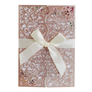 Faire-part de mariage découpé au laser en paillettes or rose avec motifs floraux et ruban crème