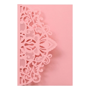 Macro detail of laser-cut floral mandala pattern on pink pearlescent wedding invitation