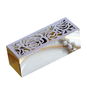 Detailed laser-cut rose pattern on white and gold metallic gift box for wedding favors
