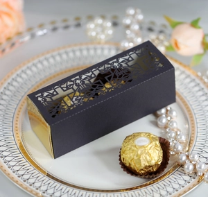 Macro view of laser-cut wedding candy box with elegant cross pattern and gold lining