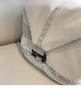 Detail shot of durable plastic hook and sturdy nylon strap on a gray travel bag