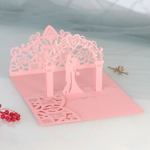 Detail of 3D pop-up wedding card with laser-cut lace floral pattern and pink bride groom