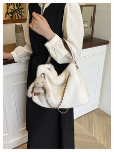 Dettaglio borsa tote in ecopelliccia bianca con tracolla in pelle e catena dorata