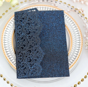 Macro detail of navy blue laser-cut floral pattern with glitter on wedding invitation
