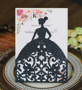 Detail of laser-cut wedding invitation featuring elegant glitter silhouette and floral pattern