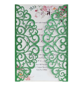 Detail of green laser-cut wedding invitation with glitter finish and floral inner card