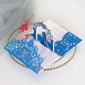 Détail d'invitation de mariage découpée au laser avec paillettes bleues et silhouette 3D