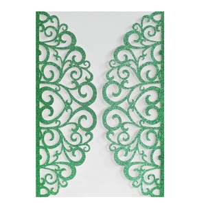 Detail of green glitter laser-cut invitation with intricate scrollwork patterns