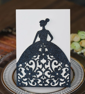 Detail of laser-cut wedding invitation showing deep blue glitter dress silhouette