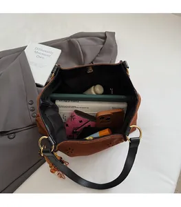 Detail view of large brown suede tote bag showing spacious interior with daily essentials