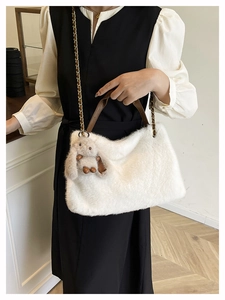 Dettaglio della borsa tote in peluche bianca con manico in pelle marrone e charm a coniglio