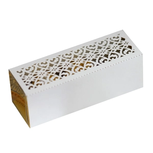 Detail showing laser-cut floral pattern on elegant white candy box with golden treats