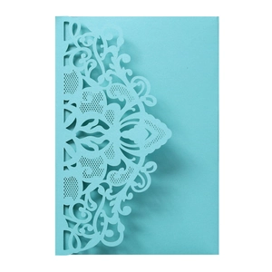 Detail of light blue laser cut wedding invitation with intricate floral mandala patterns