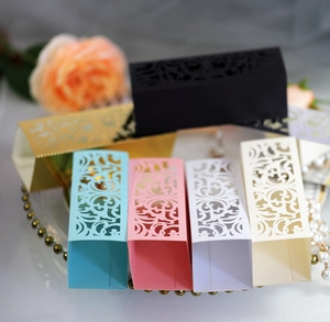 Laser cut hollow wedding candy boxes in assorted colors with floral vine patterns