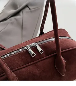 Detailansicht der glatten silbernen Doppelreißverschluss an weinroten Wildleder Handtasche