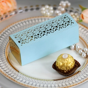 Close-up of light blue laser-cut gift box with floral patterns on a golden tray