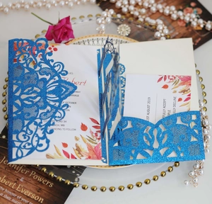Détail d'invitation de mariage bleue à paillettes découpée au laser avec carte intérieure