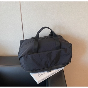 Close-up of black travel bag with double zippers and bottom compartment for shoes