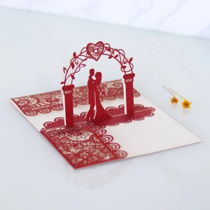 Detailed laser-cut heart arch with glitter texture and lace edge on 3D wedding card