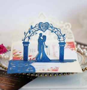 Détail du faire-part de mariage 3D avec silhouette de couple pailletée bleue et fleurs
