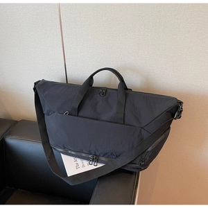 Detail of black travel bag with waterproof base shoe compartment and reinforced handles