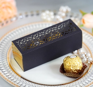Macro shot of laser-cut black gift box with gold trim on a decorative dinner plate