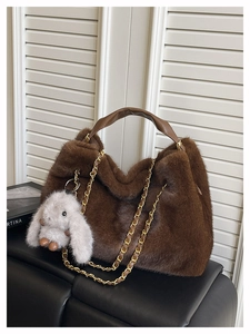 Dettaglio borsa tote in ecopelliccia marrone con catena dorata e ciondolo a forma di coniglio