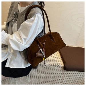 Detail der dunkelbraunen Wildleder-Schultertasche mit Herzanhänger und Motiv-Gurt